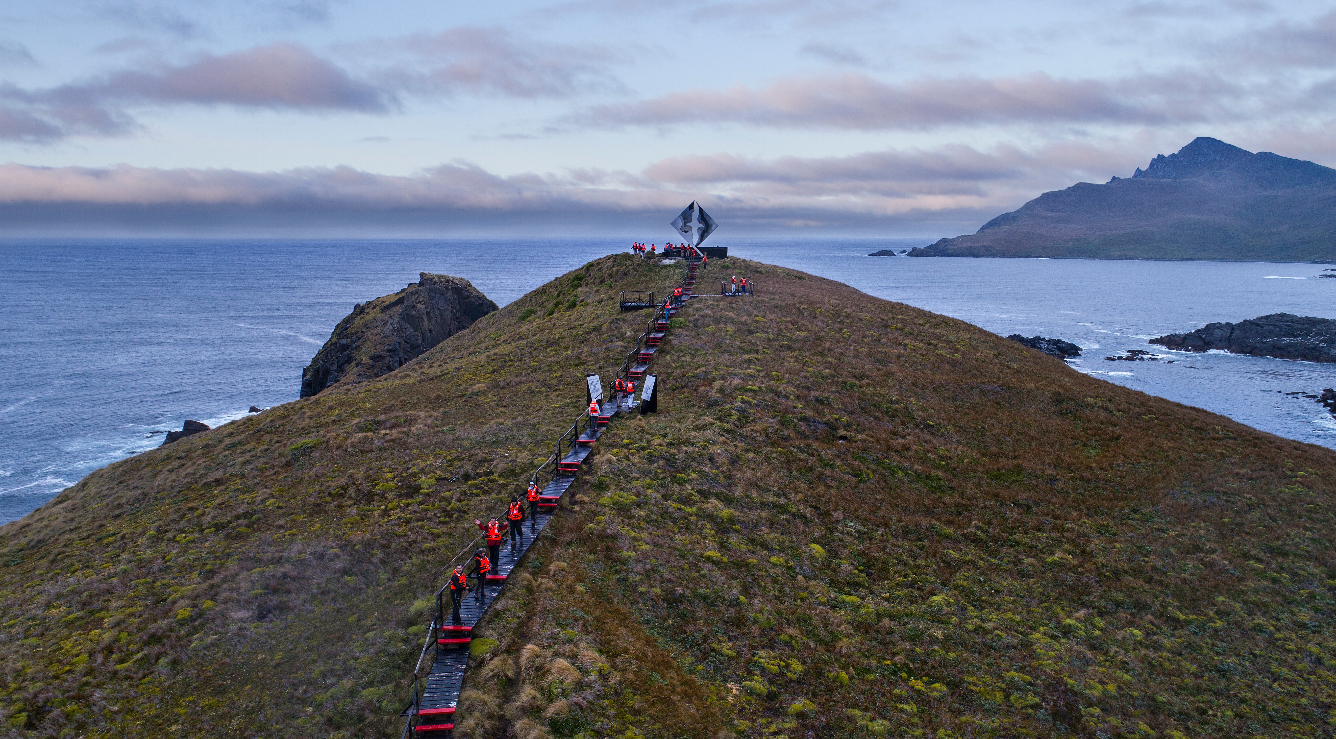 Monumento Cabo de Hornos y personas caminando para llegar a él