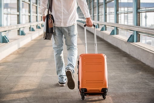 Hombre en aeropuerto con maleta de mano