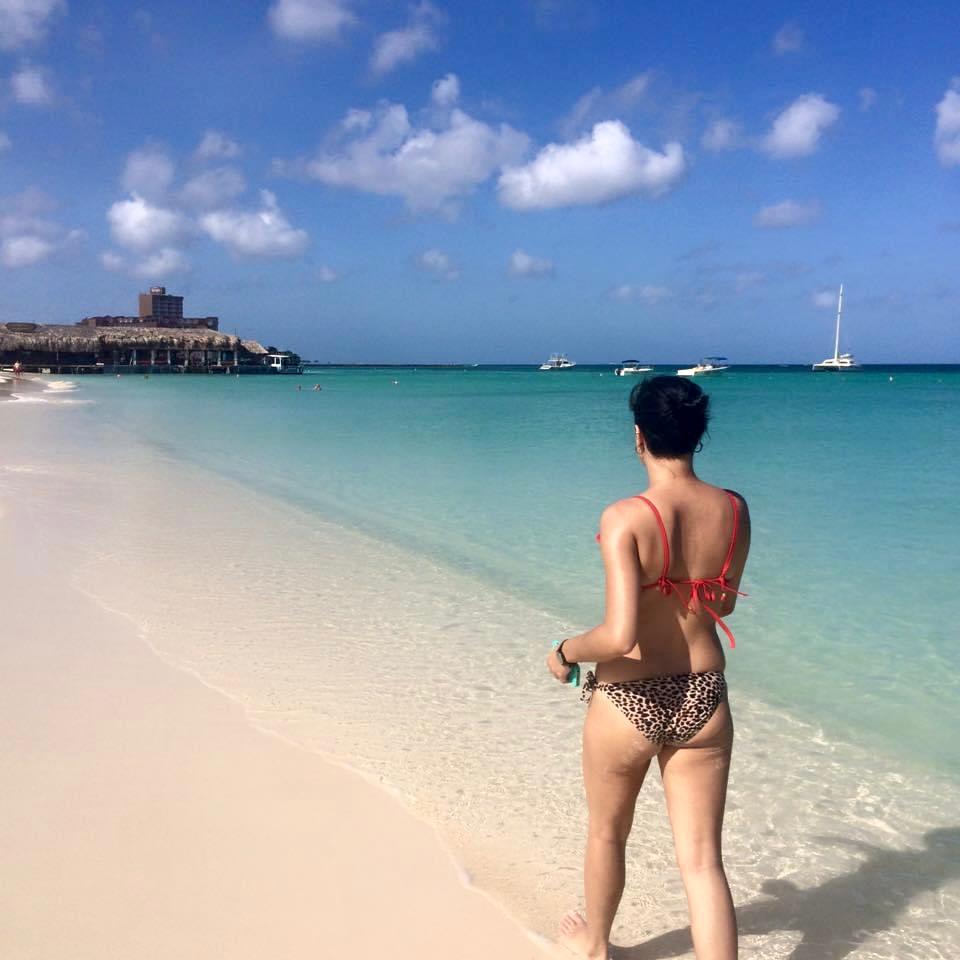 Mujer en bikini caminando por Palm Beach en Aruba