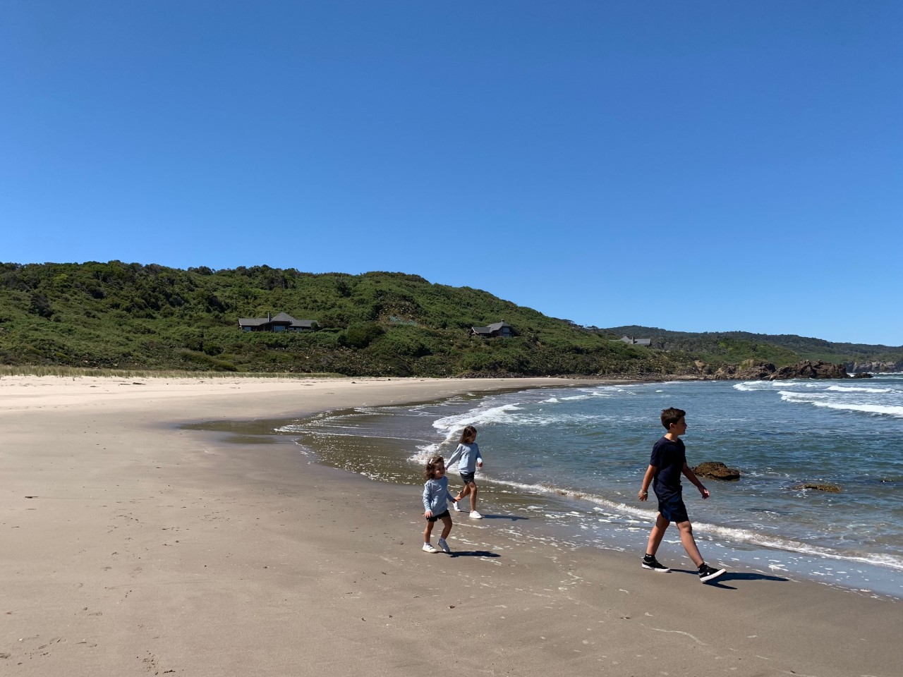 Tres niños caminando por la orilla de la paya del Hotel Mari Mari