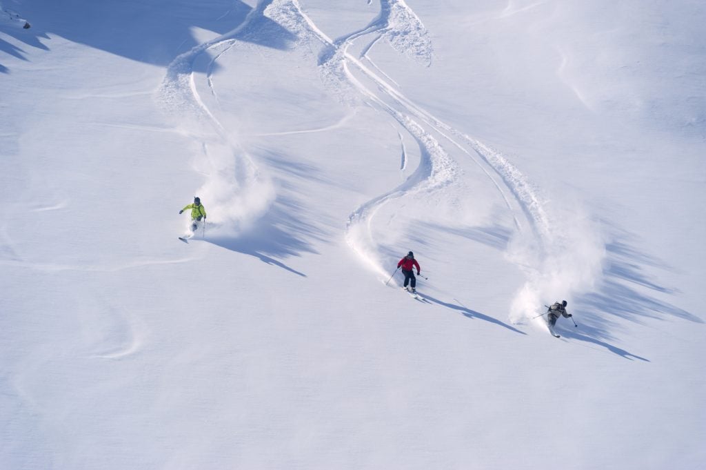 Personas esquiando en un ski all inclusive en los Alpes europeos