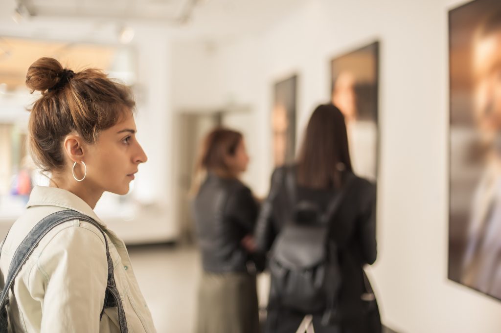 Mujer mirando un cuadro en museo